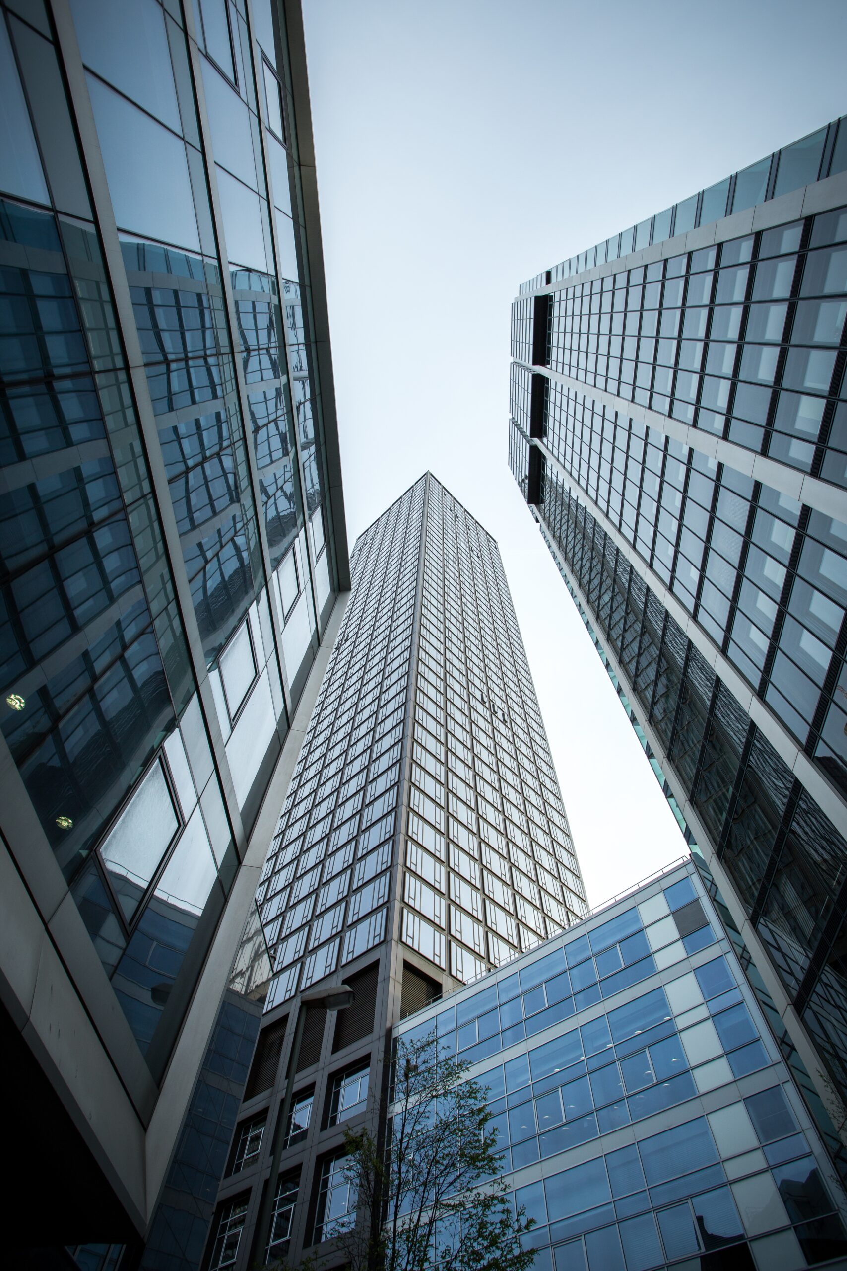 A vertical low angle shot of high rise skyscrapers in a glass facade in Frankfurt, Germany